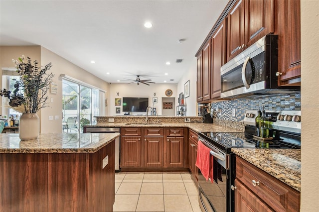 1939 Heartland Cir, Valrico, FL 33594 - kitchen with a peninsula, light tile patterned flooring, ceiling fan, a sink, and stainless steel appliances