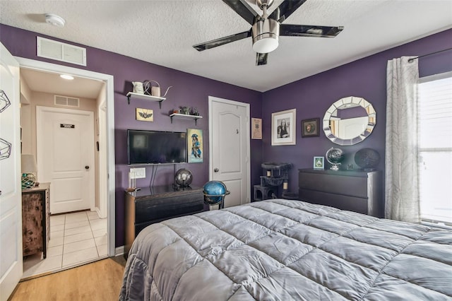 1939 Heartland Cir, Valrico, FL 33594 - bedroom featuring visible vents, a textured ceiling, light wood-style flooring, and ceiling fan