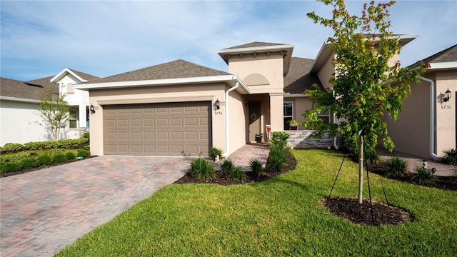 5735 Mezzana Run, Palmetto, FL 34221 - view of front of property featuring stucco siding, decorative driveway, a front yard, and a garage