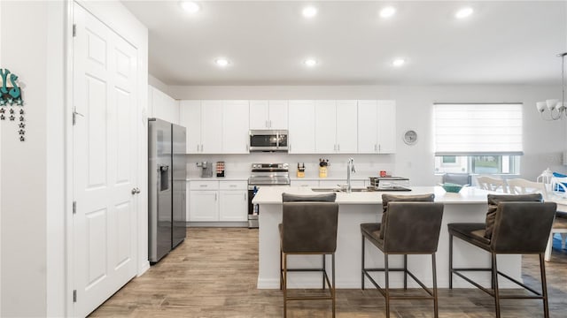 5735 Mezzana Run, Palmetto, FL 34221 - kitchen with a breakfast bar area, light countertops, a sink, and appliances with stainless steel finishes