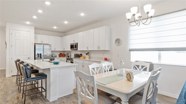 5735 Mezzana Run, Palmetto, FL 34221 - kitchen featuring stainless steel appliances, recessed lighting, a kitchen bar, white cabinetry, and light countertops