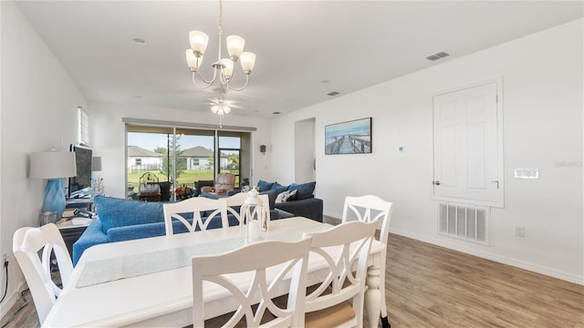 5735 Mezzana Run, Palmetto, FL 34221 - dining space with baseboards, wood finished floors, visible vents, and an inviting chandelier