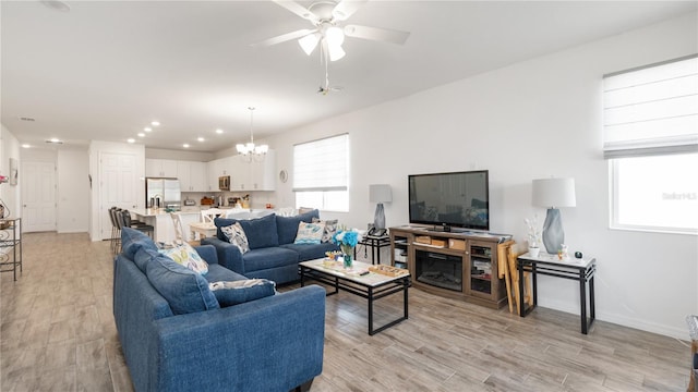 5735 Mezzana Run, Palmetto, FL 34221 - living area featuring baseboards, recessed lighting, light wood-type flooring, and ceiling fan with notable chandelier