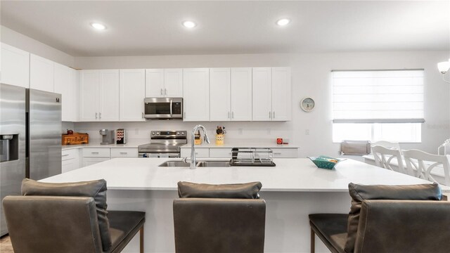5735 Mezzana Run, Palmetto, FL 34221 - kitchen featuring stainless steel appliances, light countertops, a sink, and a kitchen bar