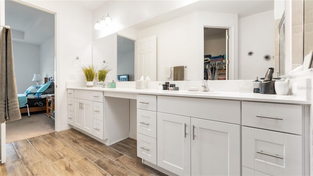 5735 Mezzana Run, Palmetto, FL 34221 - ensuite bathroom with a walk in closet, wood tiled floor, vanity, and connected bathroom