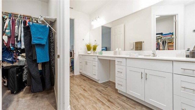 5735 Mezzana Run, Palmetto, FL 34221 - bathroom featuring a walk in closet, wood finished floors, and vanity