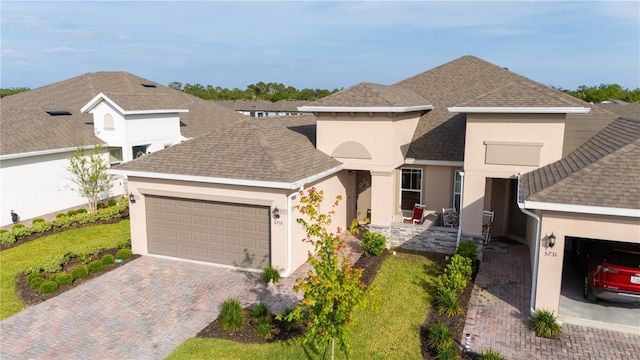 5735 Mezzana Run, Palmetto, FL 34221 - view of front of home with a garage, stucco siding, a shingled roof, and decorative driveway