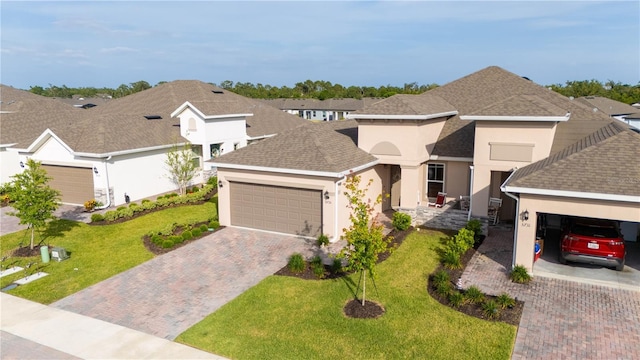 5735 Mezzana Run, Palmetto, FL 34221 - view of front of home with roof with shingles, an attached garage, a front yard, stucco siding, and decorative driveway