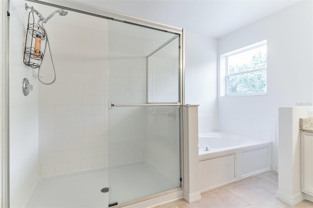 full bathroom featuring a shower stall, a bath, vanity, and tile patterned floors