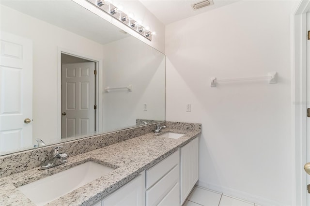 full bath featuring tile patterned flooring, double vanity, and baseboards