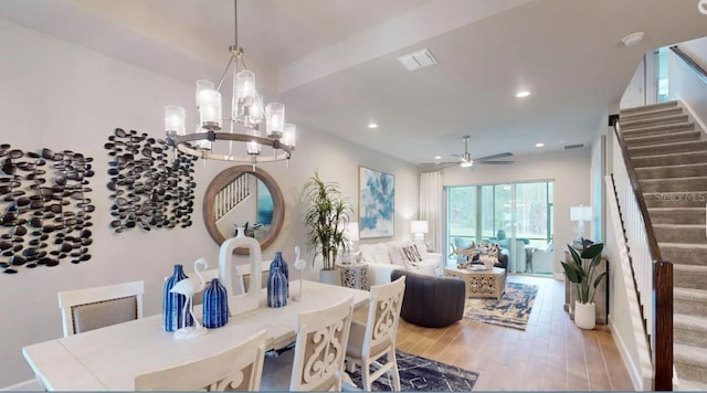 dining room with visible vents, recessed lighting, ceiling fan with notable chandelier, wood finished floors, and stairway