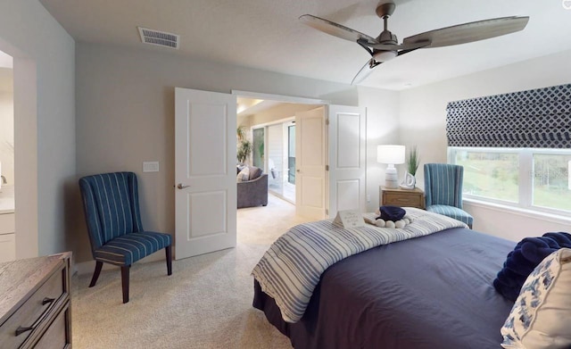 bedroom with light colored carpet, ceiling fan, multiple windows, and visible vents