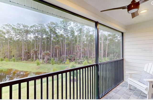balcony with a water view and a ceiling fan