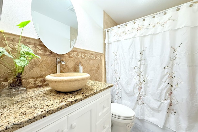 bathroom featuring toilet, tile walls, curtained shower, and vanity