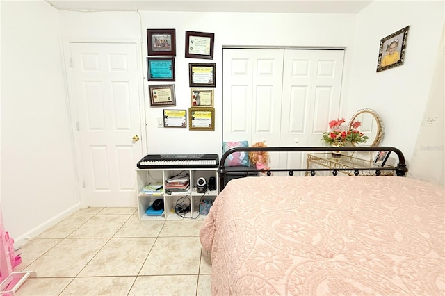 tiled bedroom featuring a closet and baseboards