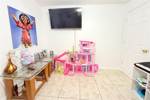 recreation room with baseboards and light tile patterned floors