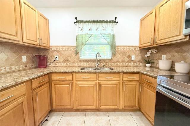 kitchen with tasteful backsplash, stainless steel range with electric stovetop, a sink, light stone counters, and light tile patterned flooring