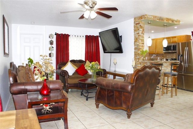 living room featuring light tile patterned floors, baseboards, and a ceiling fan