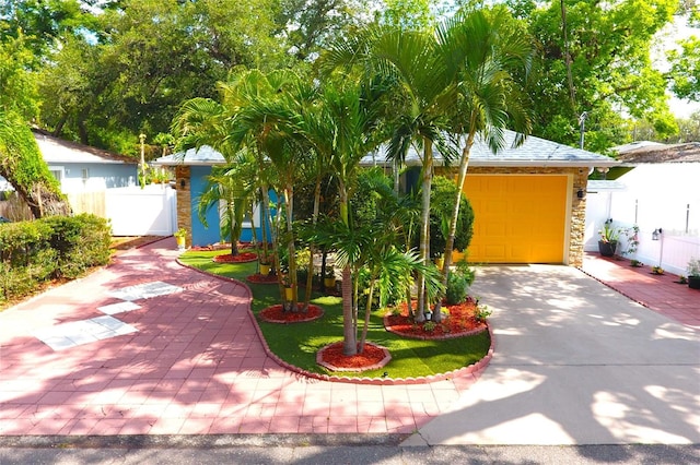 3306 E Chelsea St, Tampa, FL 33610 - view of property hidden behind natural elements with a garage, fence, a gate, and concrete driveway