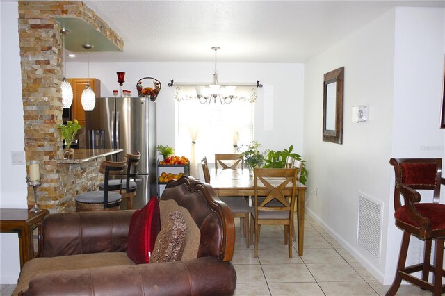 3306 E Chelsea St, Tampa, FL 33610 - dining area featuring light tile patterned floors, baseboards, visible vents, and an inviting chandelier