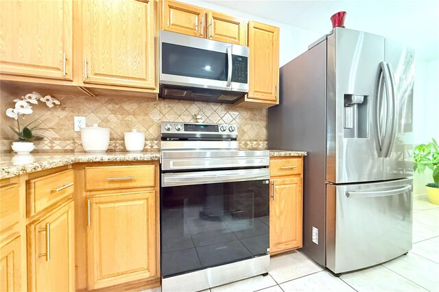 3306 E Chelsea St, Tampa, FL 33610 - kitchen with decorative backsplash, appliances with stainless steel finishes, light tile patterned floors, and light stone countertops