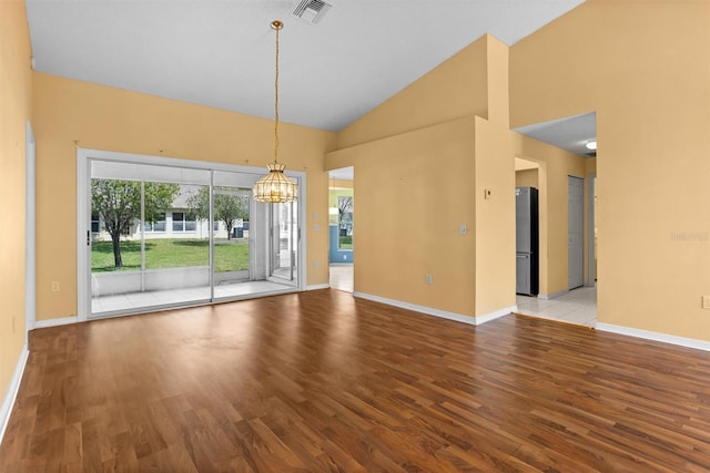 1046 Almondwood Dr, Trinity, FL 34655 - spare room featuring visible vents, a chandelier, baseboards, wood finished floors, and high vaulted ceiling
