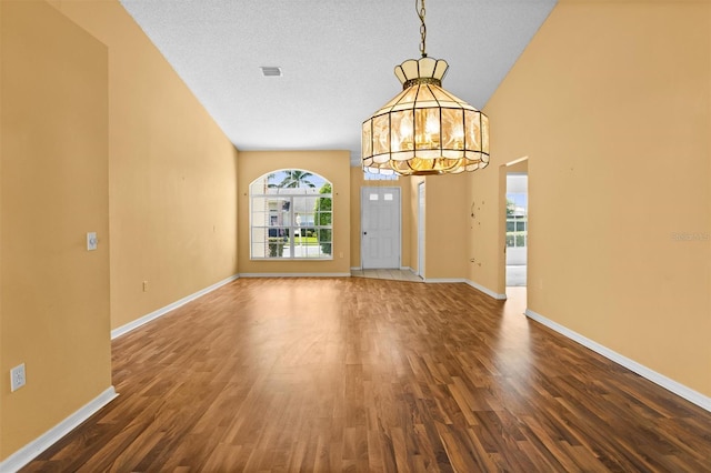 1046 Almondwood Dr, Trinity, FL 34655 - entrance foyer with a notable chandelier, dark wood-type flooring, visible vents, baseboards, and a textured ceiling