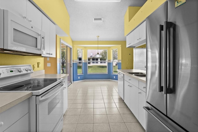 1046 Almondwood Dr, Trinity, FL 34655 - kitchen with white appliances, visible vents, light countertops, white cabinets, and french doors