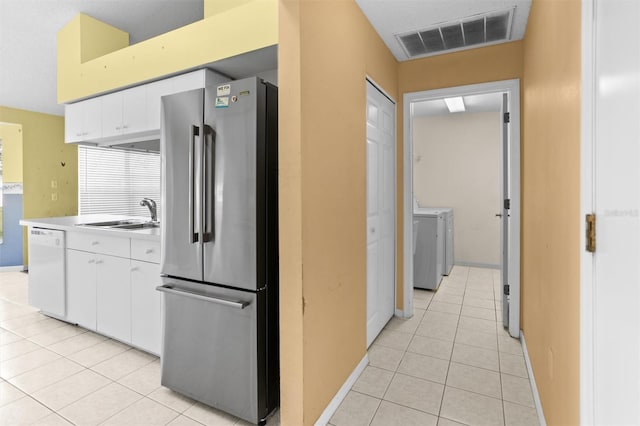 1046 Almondwood Dr, Trinity, FL 34655 - kitchen featuring a sink, light tile patterned flooring, visible vents, dishwasher, and freestanding refrigerator