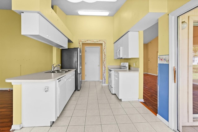 1046 Almondwood Dr, Trinity, FL 34655 - kitchen featuring white appliances, light countertops, white cabinets, a sink, and baseboards