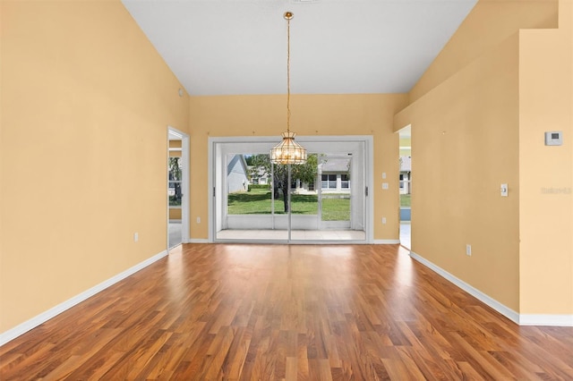 1046 Almondwood Dr, Trinity, FL 34655 - empty room with wood finished floors, a chandelier, and baseboards