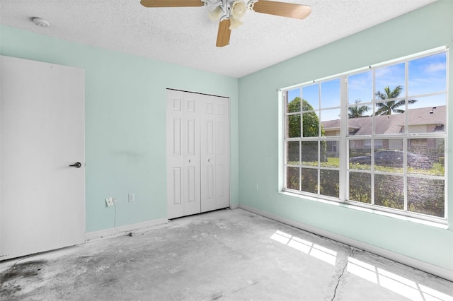 1046 Almondwood Dr, Trinity, FL 34655 - unfurnished bedroom featuring a textured ceiling, ceiling fan, a closet, and baseboards