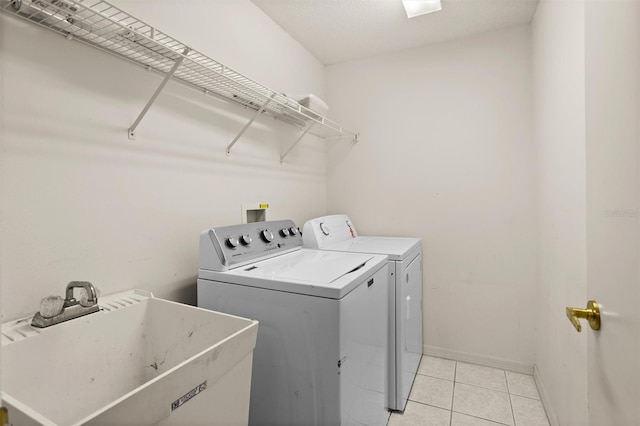 1046 Almondwood Dr, Trinity, FL 34655 - washroom with a sink, washer and clothes dryer, light tile patterned flooring, laundry area, and baseboards