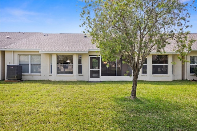 1046 Almondwood Dr, Trinity, FL 34655 - rear view of house featuring a lawn, cooling unit, a shingled roof, and a sunroom