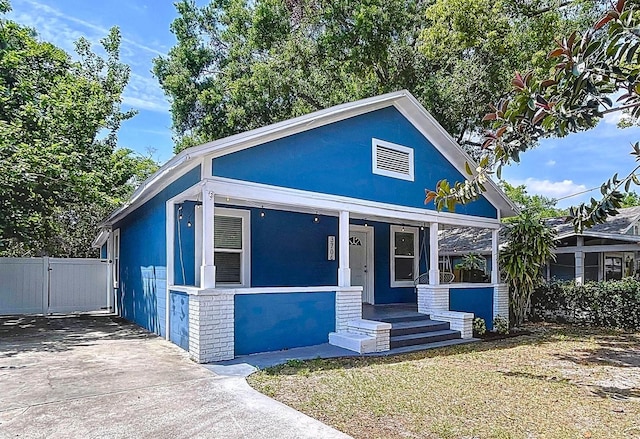 bungalow-style house featuring a gate, fence, and a porch