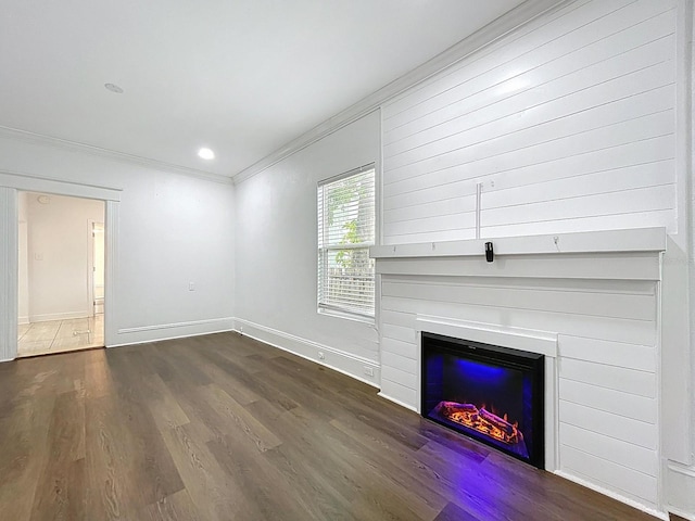 unfurnished living room featuring ornamental molding, a glass covered fireplace, wood finished floors, and baseboards