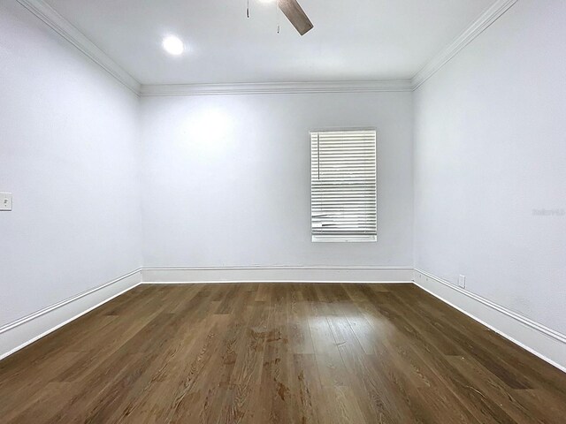 spare room featuring crown molding, dark wood-style floors, ceiling fan, and baseboards