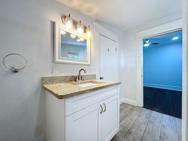 bathroom with baseboards, wood finished floors, and vanity