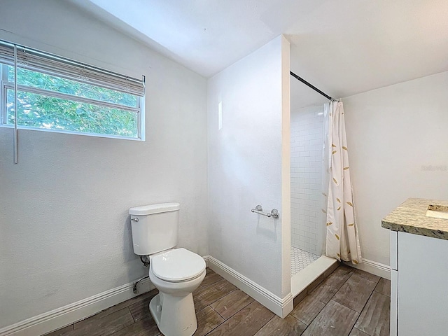 full bathroom featuring a shower stall, vaulted ceiling, toilet, baseboards, and wood finish floors
