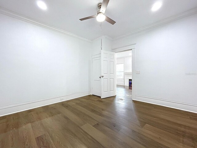 spare room with crown molding, ceiling fan, wood finished floors, and baseboards