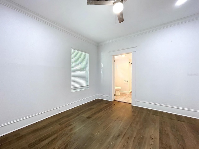 empty room with crown molding, a ceiling fan, baseboards, and dark wood-type flooring