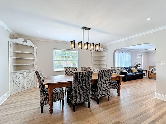 4231 8th St N, Saint Petersburg, FL 33703 - dining space featuring light wood finished floors, crown molding, and arched walkways