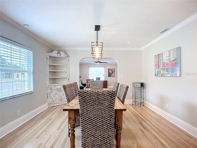 4231 8th St N, Saint Petersburg, FL 33703 - dining area featuring ornamental molding, light wood-type flooring, baseboards, and arched walkways