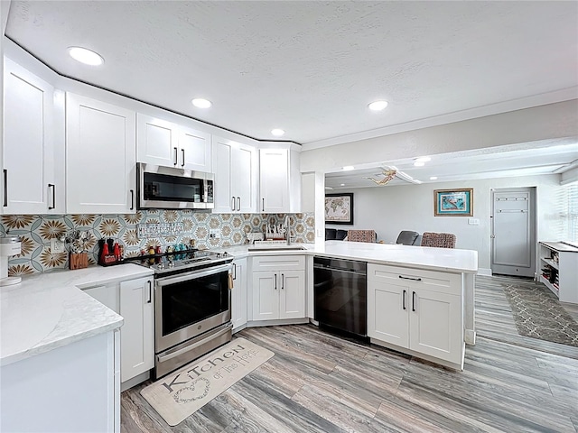 4231 8th St N, Saint Petersburg, FL 33703 - kitchen featuring a sink, a peninsula, recessed lighting, white cabinetry, and appliances with stainless steel finishes