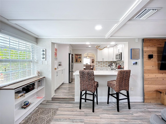 4231 8th St N, Saint Petersburg, FL 33703 - kitchen featuring appliances with stainless steel finishes, visible vents, a kitchen bar, a peninsula, and beam ceiling