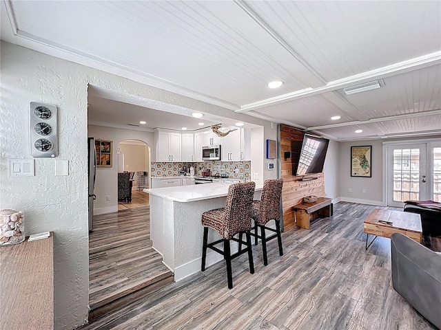 4231 8th St N, Saint Petersburg, FL 33703 - kitchen with arched walkways, light countertops, a healthy amount of sunlight, and appliances with stainless steel finishes