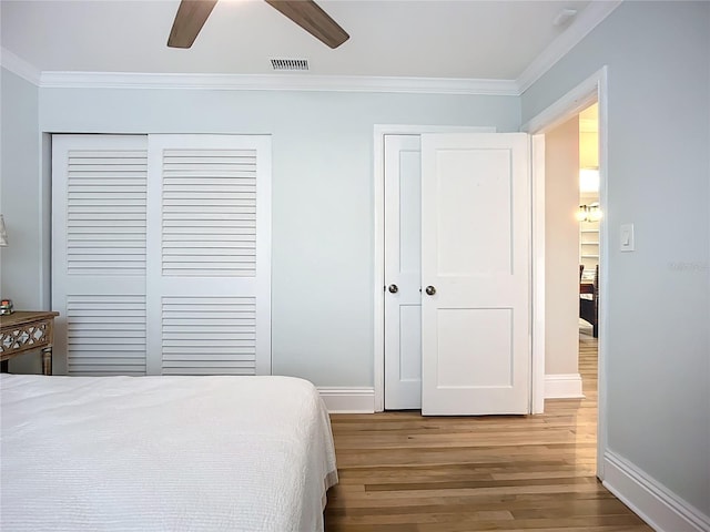 4231 8th St N, Saint Petersburg, FL 33703 - bedroom with baseboards, crown molding, visible vents, and wood finished floors