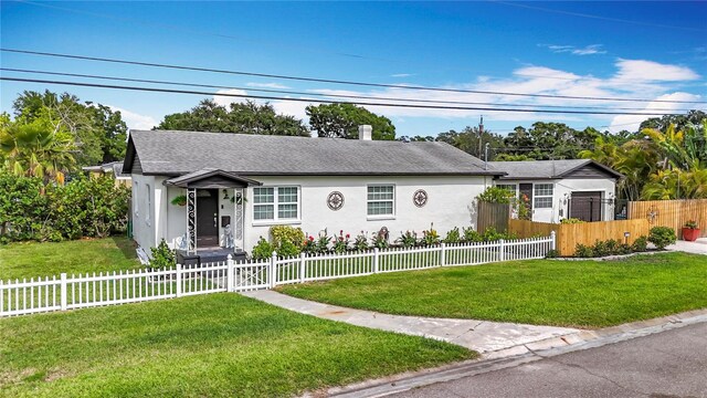 4231 8th St N, Saint Petersburg, FL 33703 - view of front of house with a fenced front yard, stucco siding, roof with shingles, and a front yard