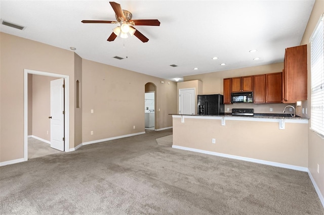 kitchen featuring arched walkways, brown cabinetry, a ceiling fan, visible vents, and black appliances