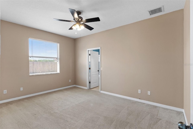unfurnished room featuring visible vents, ceiling fan, and light colored carpet